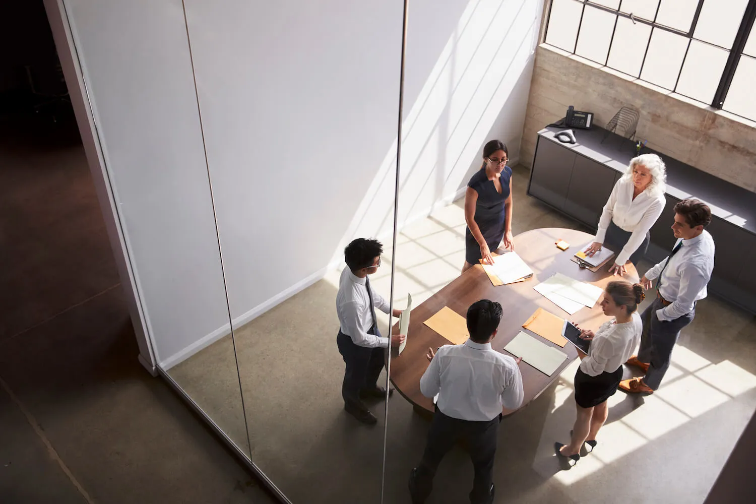 Ein Expertenteam steht gemeinsam an einen Tisch und bespricht etwas