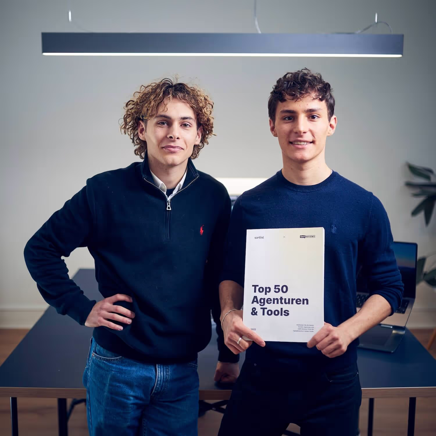 Elia und Emil halten den Guide von OMR hoch, indem sie auf Platz 1 der Top 50 Agenturen in Deutschland gelistet sind